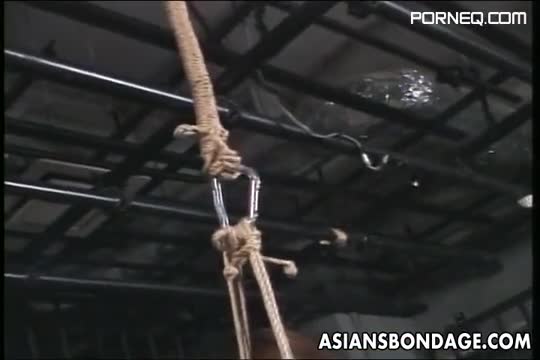 Asian Is Hung From The Ceiling With Rope