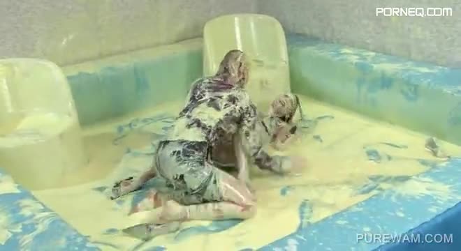 Clothed lesbos have fun in a pool of messy paint