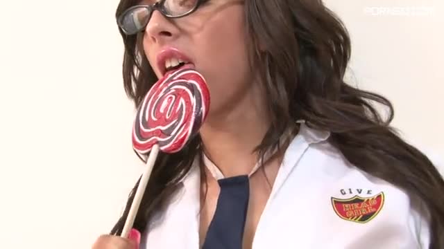 Nerdy brunette enjoys licking lolly while stripping
